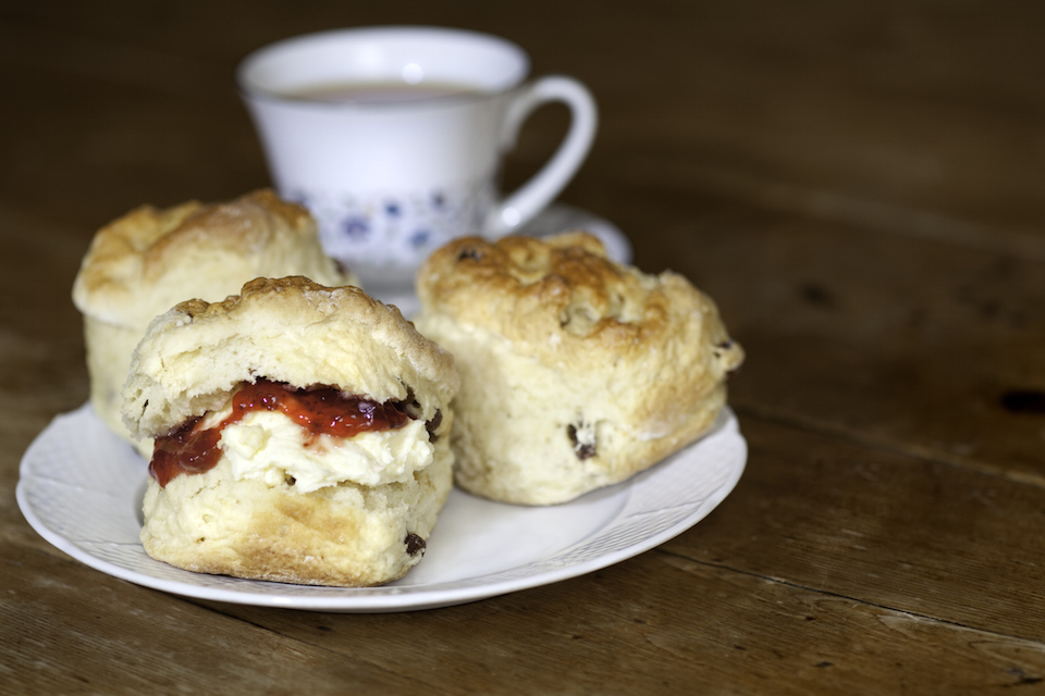 Delicious scones, cream and jam on a wooden table